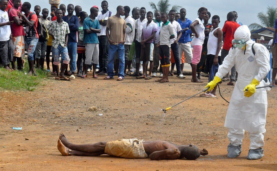 22. A health worker sprays a man with disinfectants as he is suspected of dying due to Ebola virus in Monrovia, Liberia - September 4, 2014.