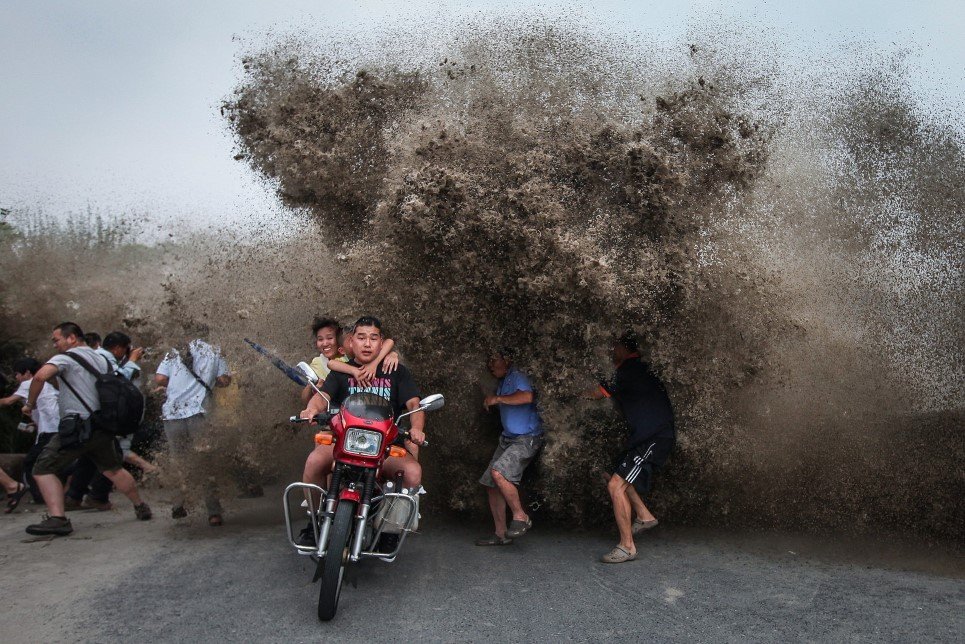 30. Visitors look to avoid a high wave hitting the bank of Qiantang River in Hangzhou, Zhejiang province, China - August 13, 2014.