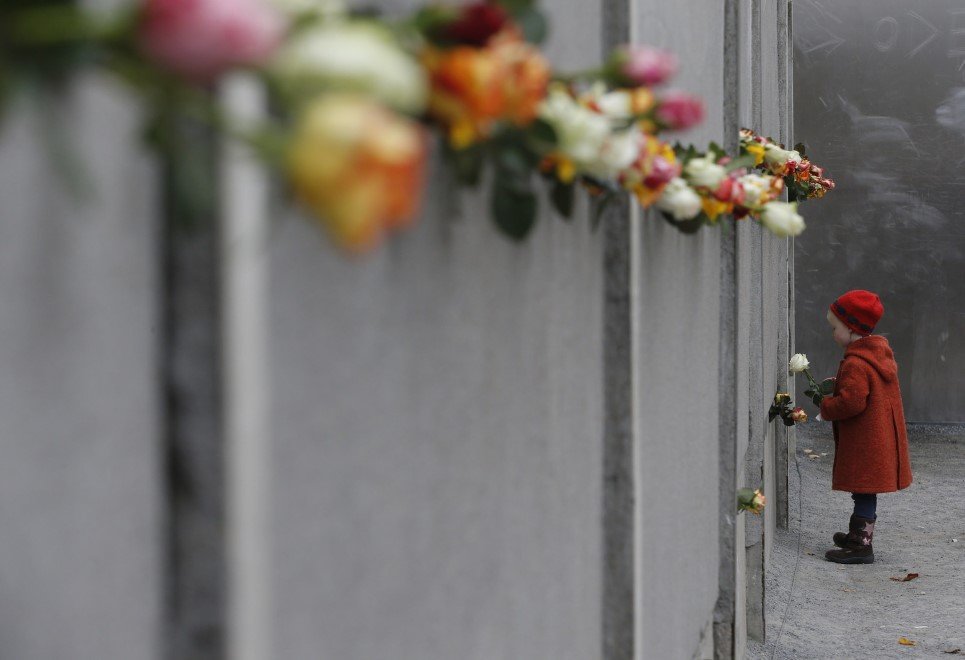 41. A young girl places a rose at the Berlin Wall memorial in Bernauer Strasse, at the 25th anniversary of fall of Berlin Wall - November 9, 2014.