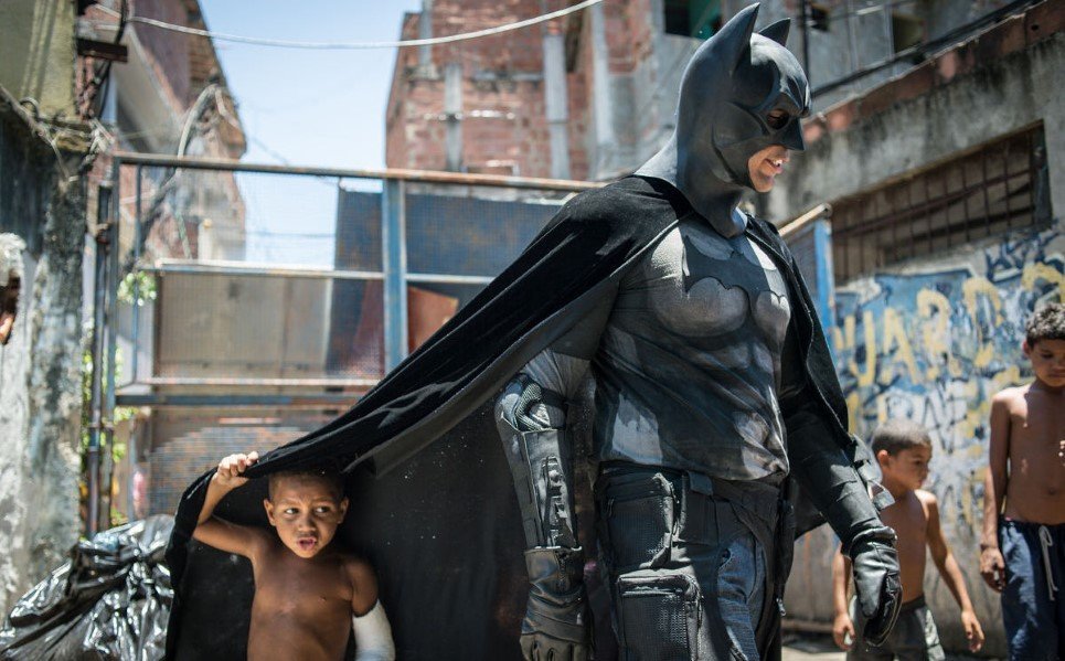 56. Children play around a man disguised as Batman at the Favela do Metro slum, in Rio de Janeiro, Brazil - January 9, 2014.