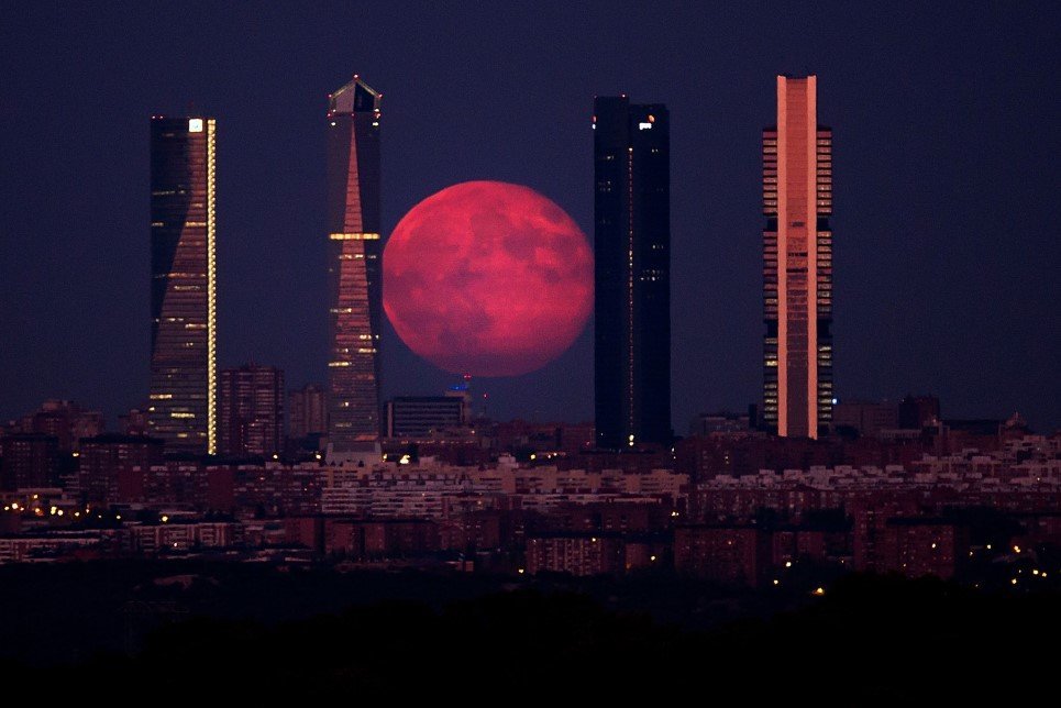 58. A spectacular super moon shines through the Four Towers Madrid skyscrapers – August 11, 2014.