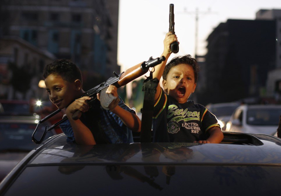 62. Palestinian children hold guns as they celebrate after a ceasefire in Gaza City - August 26, 2014.