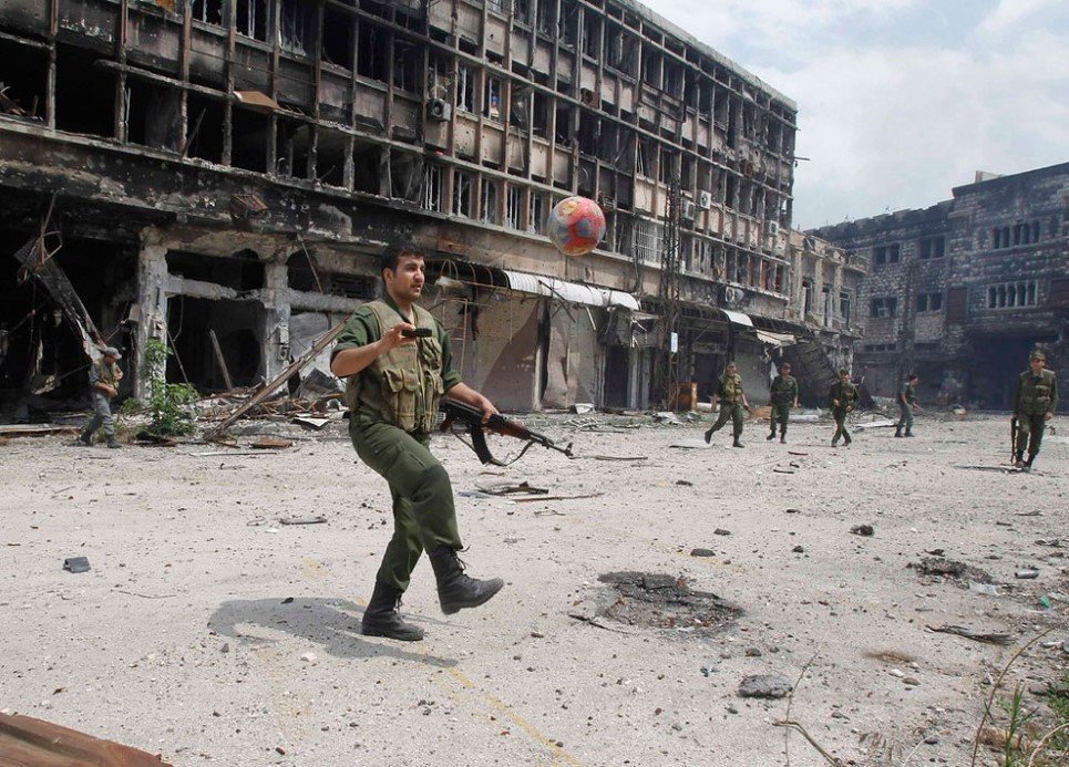 80. Loyal forces of President Bashar al-Assad play football in the al-Hamdeya neighbourhood of Homs city - May 9, 2014.