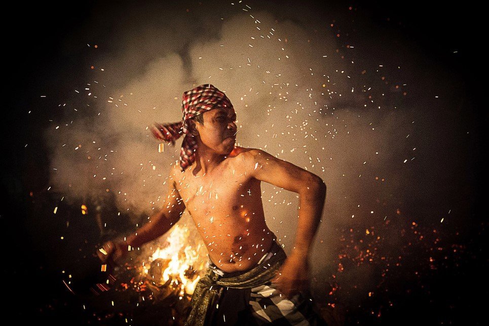 81. A Balinese man throws a burned coconut husk during the “Mesabatan Api” ritual ahead of Nyepi Day Gianyar, Bali, Indonesia - March 30, 2014.