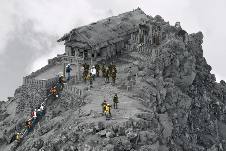 85. Rescue workers climb to an ash-covered shrine near the summit of Mt. Ontake, Japan, which erupted and killed 56 people.