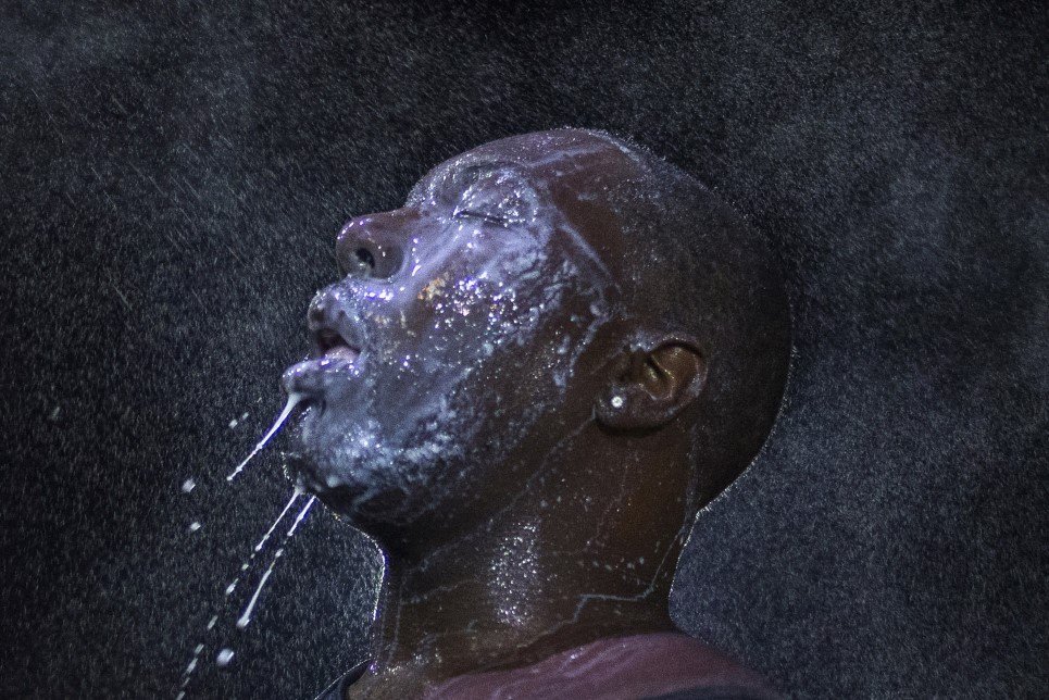96. A man is doused with milk and sprayed with mist after being hit by an eye irritant from security forces trying to disperse protestors in Ferguson - August 20, 2014