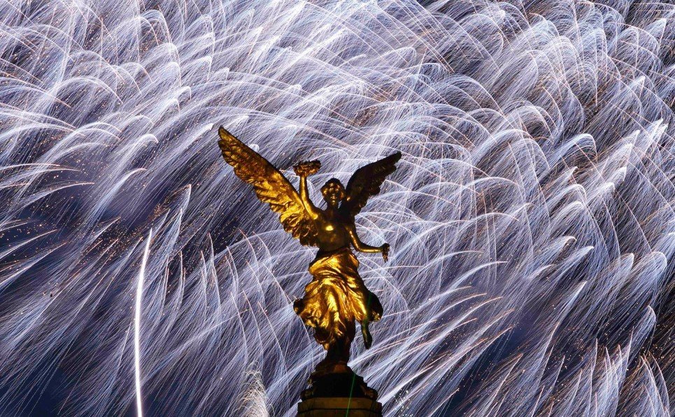 Mexico's golden Angel of Independence stands in front of fireworks during New Year's celebrations in Mexico City, Tuesday, Jan. 1, 2008. (AP Photo/Gregory Bull)