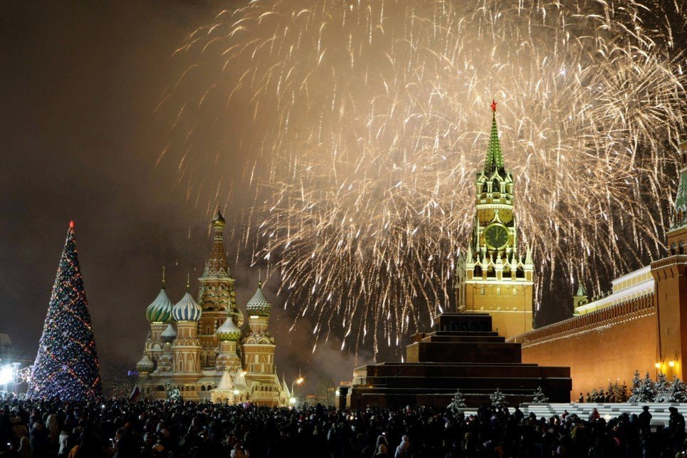 Russians celebrate the New Year on Red Square in Moscow, with the Kremlin in the background, right, and St. Basil's cathedral in background, left, Friday, Jan. 1, 2010. Tens of thousands of people gathered on the Square to celebrate the new year, and view the fireworks as the clock on the Kremlin's Spassky Tower, right, struck midnight. (AP Photo/Mikhail Metzel)