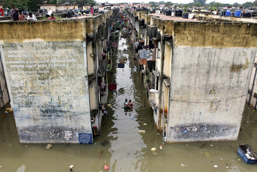 Indian people gather around a residential area that was flooded after heavy rains in Chennai – Nov. 18, 2015.