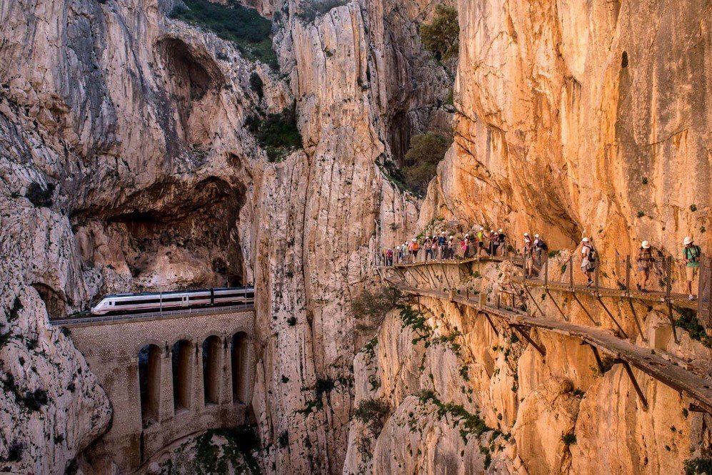 A train passes through a tunnel as tourists walk along the re-opened 'El Caminito del Rey' footpath on April 1, 2015 in Malaga, Spain. The path was built in 1905 and is known as the most dangerous walkway in the world. It was closed after two fatal accidents in 1999 and 2000. The restoration for a safer path began in 2011 and reportedly cost 5.5 million euros.
