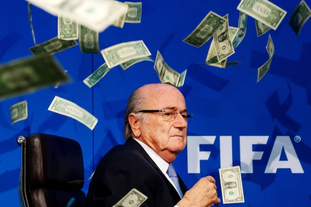Comedian Simon Brodkin throws dollar bills at FIFA President Joseph S. Blatter during a press conference at the Extraordinary FIFA Executive Committee Meeting in Zurich, Switzerland – July. 20, 2015