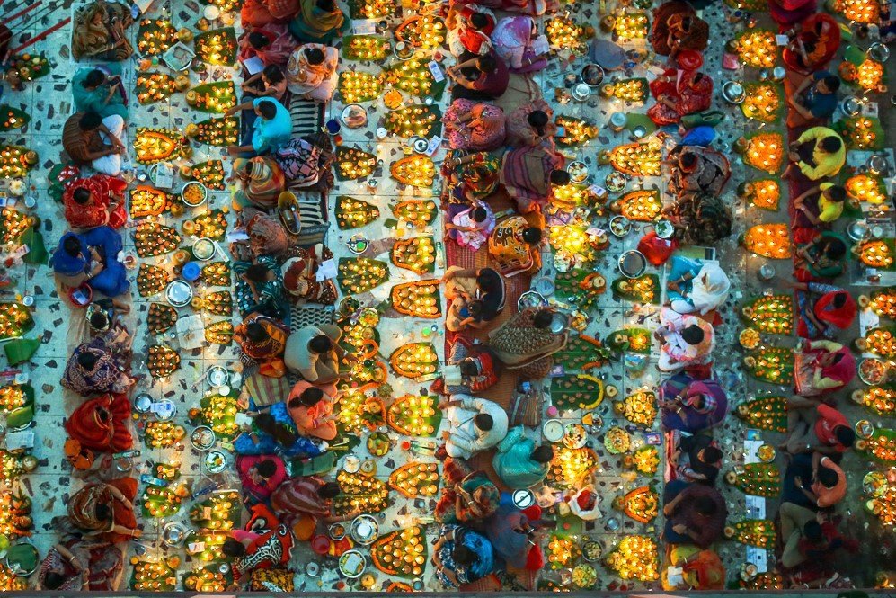 Hindu believers sitting together on floor in Lokenath Brahmachari Temple at Swamibag, Dhaka during a prayer.