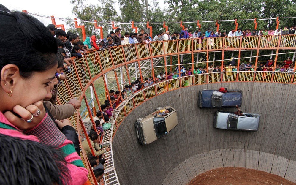 Villagers watch stuntmen performing at the show of ‘Well of Death’ during the annual Farmers Fair at Shama Chak Jhiri, India – Nov. 25, 2015.