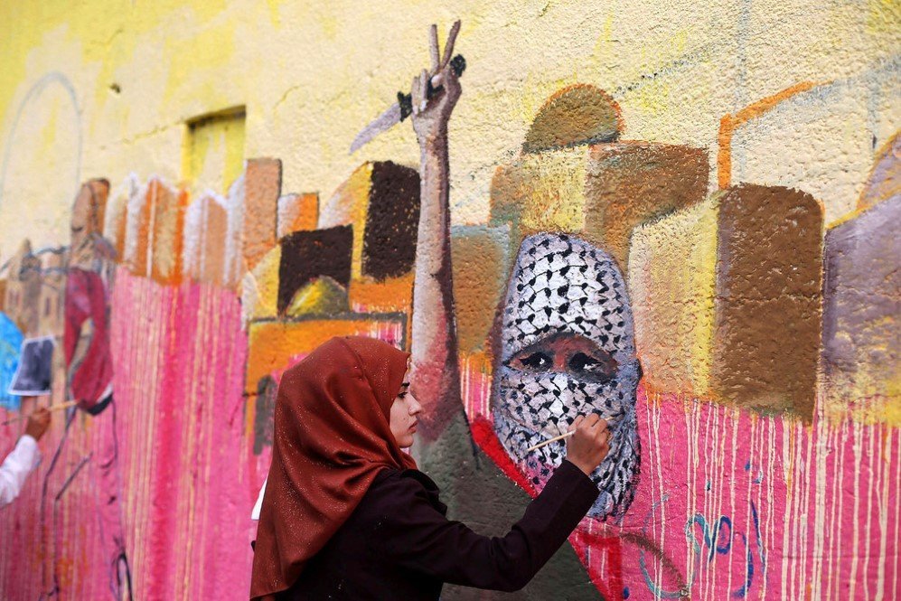 A Palestinian woman painting a mural in support of Palestinians committing stabbing attacks against Israelis –Nov. 3, 2015.