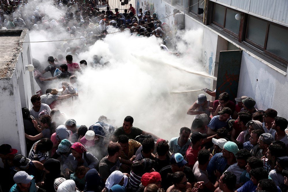 Policemen spray fire extinguishers to disperse hundreds of refugees in Kos, Greece – Aug. 11, 2015.