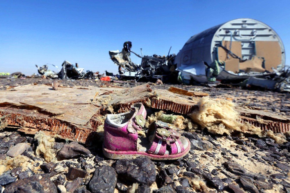 A child’s shoe is seen in front of debris from a Russian airliner that crashed at the Hassana area in Arish city, north Egypt killing all 224 people onboard. – Nov. 1, 2015