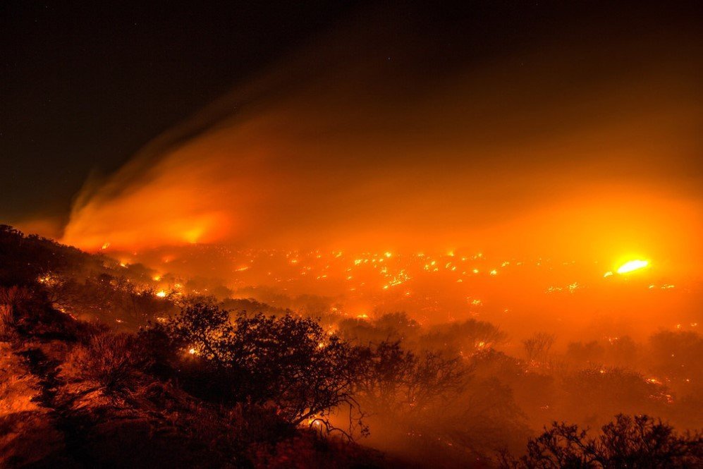 Fires burn along Baldy Mesa Road near Interstate 15 in San Bernardino County, California. The 5.5-square-mile fire destroyed 20 vehicles on the freeway before burning three homes and 44 more vehicles in the community of Baldy Mesa – July 18, 2015