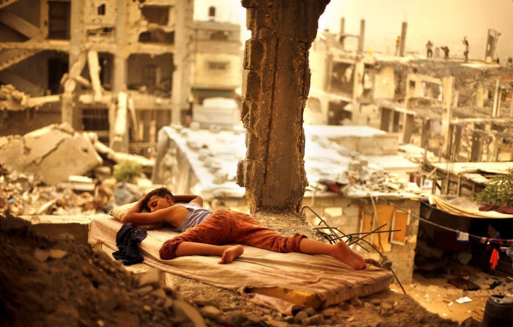 A Palestinian boy is found sleeping on a mattress inside the remains of his family’s house that was destroyed by Israeli shelling during a 50-day war in 2014 – Sept. 8, 2015.