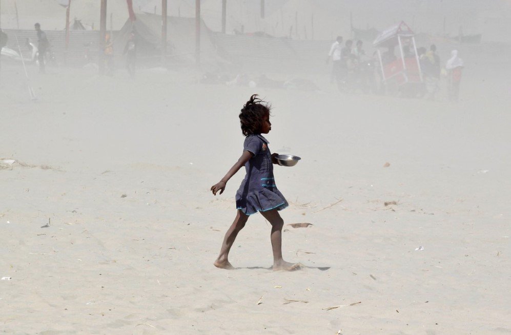 a girl walks amidst a dust storm on the banks of the ganges river in allahabad india on february 24 2017
