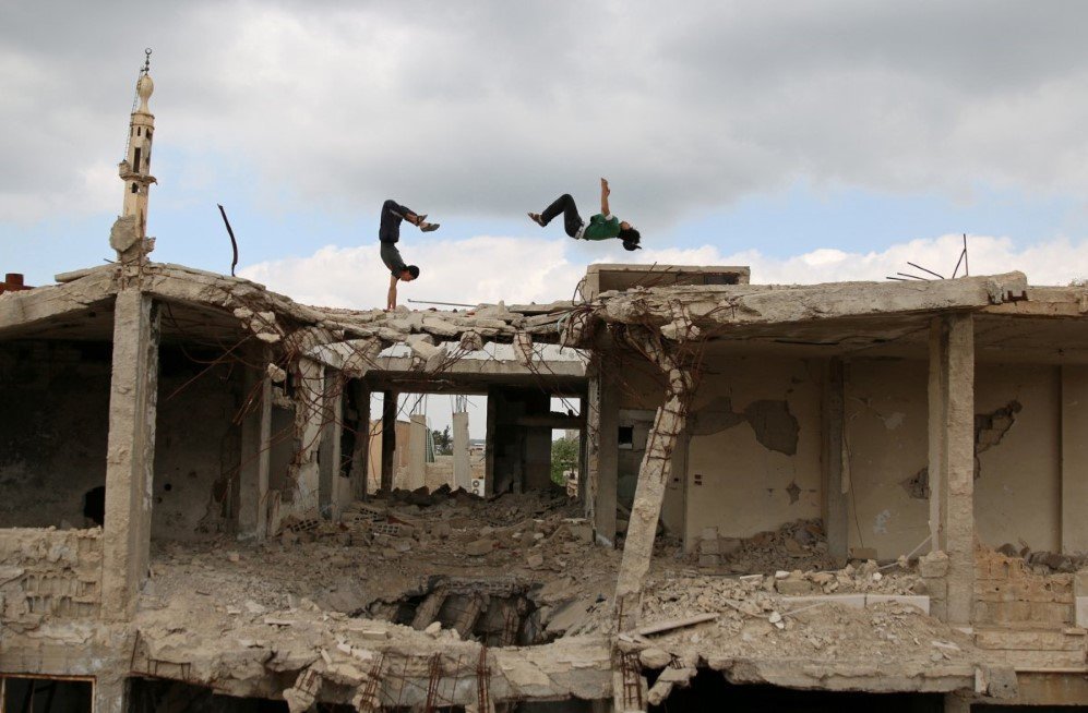 two teens demonstrate their parkour skills amid damaged buildings in the rebel held city of inkhil west of deraa syria on april 7 2017