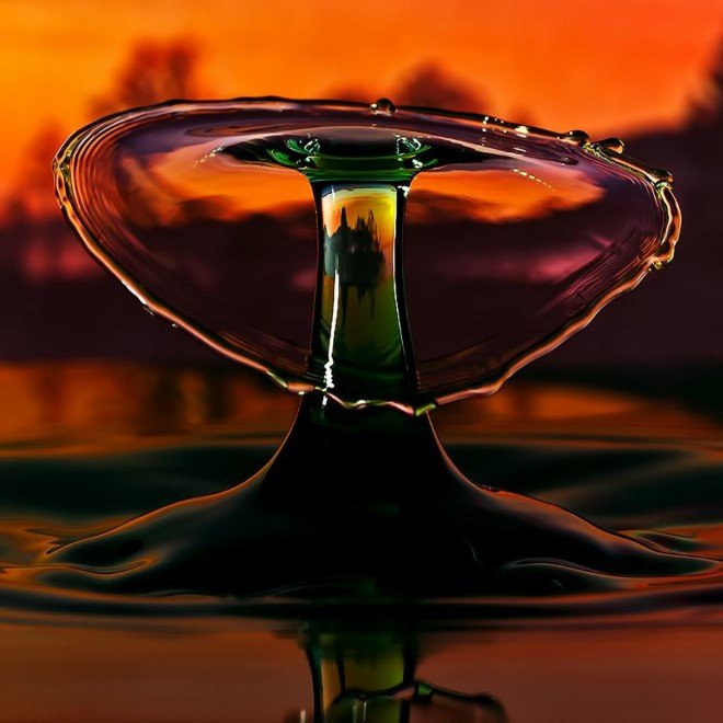 A splash with trees in the backgound at sunset