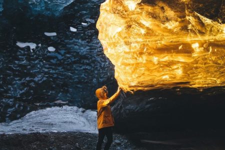 This photographer captures the Icelandic ice cave basking in an amber glow